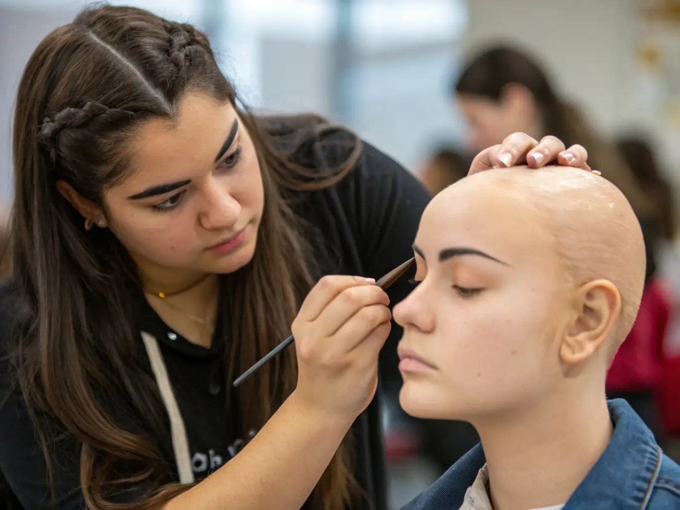 A student practicing eyebrow shaping techniques on a mannequin head during a brow shaping workshop at Meytav Boutique, highlighting the hands-on learning experience.